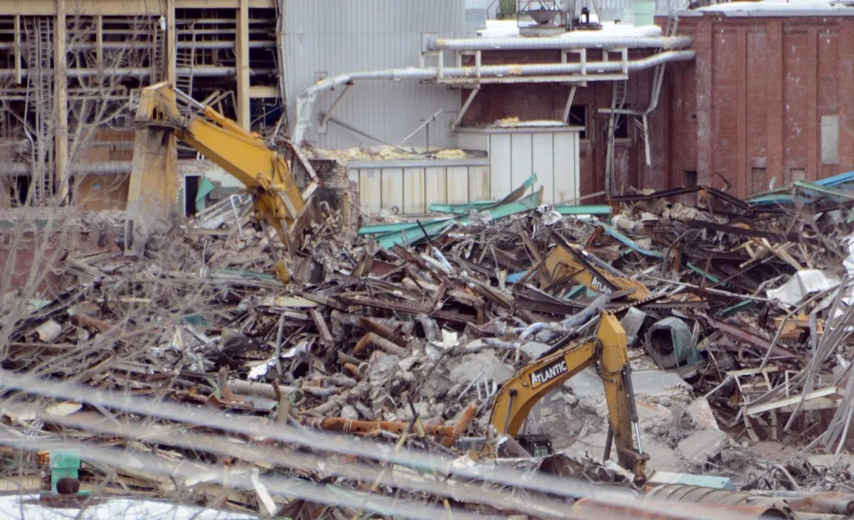 Three excavators continue to organize debris at the former Great Northern Paper Co. LLC mill site in East Millinocket on Tuesday. Credit: Nick Sambides Jr. | BDN